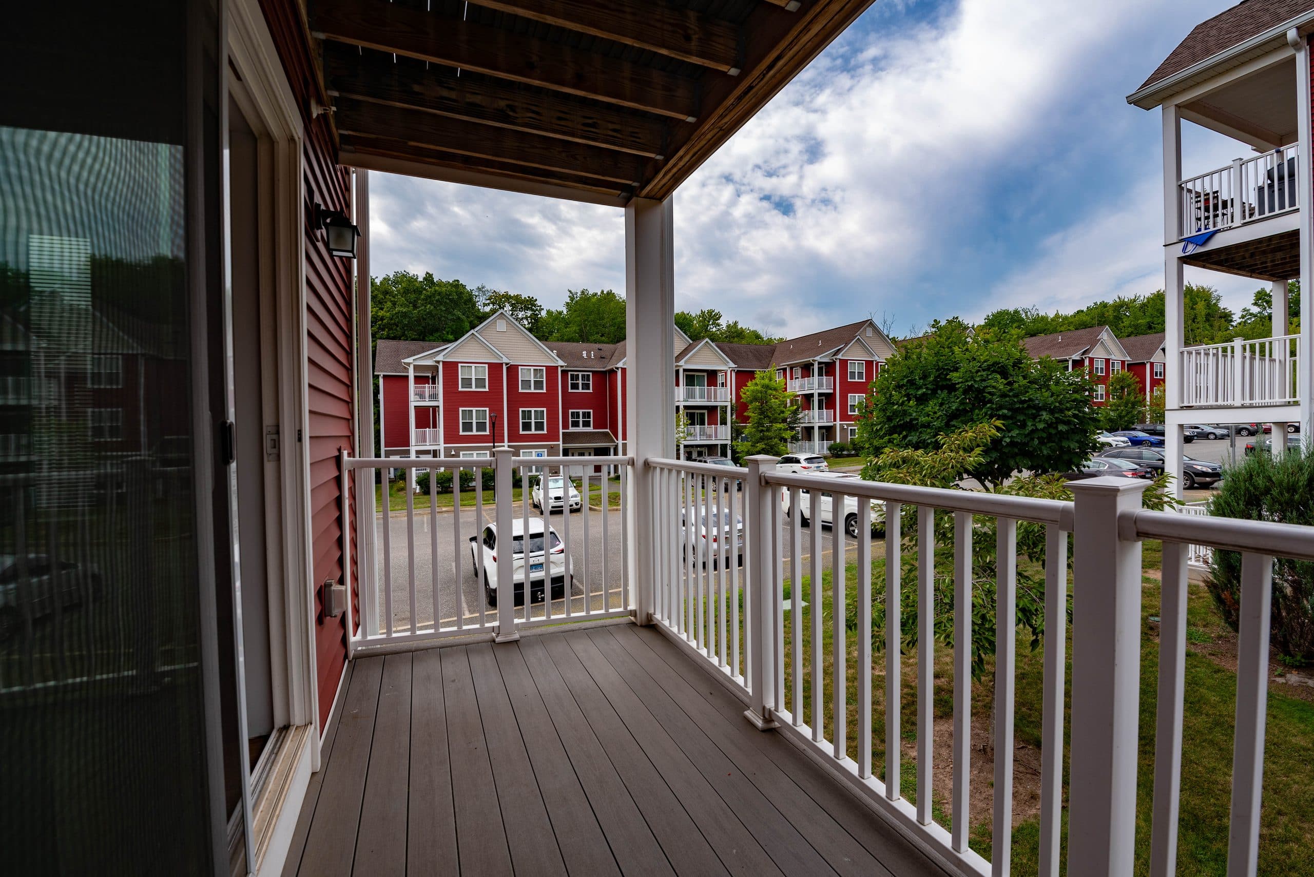 Looking out from a covered private balcony at Brook Hill Village across the parking court to the buildings beyond
